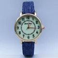 Macro detail of casual quartz watch with luminous green dial and blue denim strap - Blue