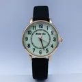 Close-up of vintage gold quartz watch with black Arabic numerals and leather strap - Black