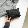 Schwarze gesteppte Umschlag-Clutch mit Blumenmuster aus glänzendem Nylon-Stoff - Schwarz
