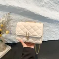 Quilted cream crossbody bag with gold U-shaped metal lock and elegant chain strap - White