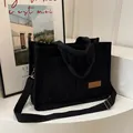 Grande borsa tote in velluto a coste nero con etichetta fashion e tracolla larga - Nero