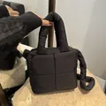 Chic black quilted down-filled nylon handbag with thick handles and detachable strap - Black