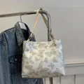 Off-white tote bag featuring elegant blue and gold embroidered butterfly patterns - White