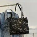 Black tote bag featuring golden butterfly embroidery and slim shoulder straps - Black
