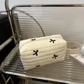 Neceser acolchado beige con bordado de lazos negros y práctica asa de transporte - Blanco