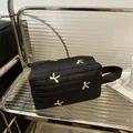 Neceser negro acolchado con bordado de lazo rosa y asa lateral de tela suave - Negro