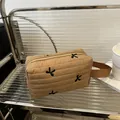 Quilted light brown makeup bag featuring black bow embroidery and side handle - Khaki