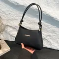 Elegante bolso de hombro negro con correa anudada y detalles metálicos dorados - Negro
