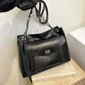 Bolso tote de cuero negro brillante con cadena y bolsillo con cierre giratorio - Negro