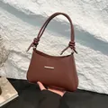 Bolso de hombro minimalista marrón oscuro en cuero sintético con elegante barra dorada - Marrón