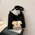 Black corduroy shoulder bag featuring a white plush cartoon dog patch and drawstring - Black
