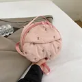 Pink quilted round crossbody bag featuring bow embroidery and a woven handle - Pink
