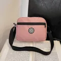 Pink canvas crossbody bag with adjustable strap and sport logo on book background - Pink