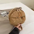 Mini khaki round quilted backpack featuring delicate white bow embroidery and top handle - Brown