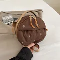 Deep brown quilted mini crossbody bag with white bow embroidery and orange puller - Brown