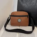 Brown canvas crossbody sport bag with adjustable strap and front zipper pocket - Brown