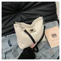 Detail of corduroy tote bag featuring bear leather patch and metal chain strap - White