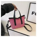 Detail of mini crossbody bag showing magenta nylon material and black woven handles - Rose Red