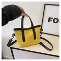 Détail du cabas en toile jaune avec poignées noires et bandoulière amovible - Jaune