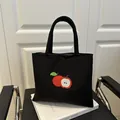 Borsa tote nera in tela con un ricamo di mela rossa di alta qualità sulla parte frontale - Nero