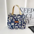Donkerblauwe canvas draagtas met witte letterprints en beige geweven handgrepen - Alfabet Blauw