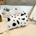 Corduroy storage bag featuring a stylish black and white cow print with a secure zipper - Cow Print White
