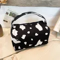 Chic cow print corduroy pouch featuring a sturdy handle and secure zipper closure - Cow Print Black