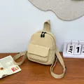 Detalle de mini mochila de pana beige con bolsillo de solapa en mesa de madera - Caqui