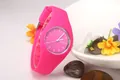 Close-up of pink Geneva silicone watch with white dial details on a decorative plate - Rose Red