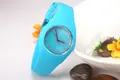 Detail of cyan Geneva silicone watch leaning on a white bowl with decorative flowers - Light Blue