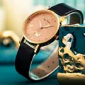 Detailed macro of a women's quartz watch with butterfly pattern and rhinestone markers - Black
