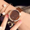 Close-up of a women's quartz watch with a hollow brown dial and rose gold metal case - Brown Watch With Pearl Rhinestone Bracelet (No Box)