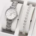 Nahaufnahme von Damen-Quarzuhr und herzförmigem Strass-Armband in einer Geschenkbox - Uhr Armband Und Klappbox / Silber Weiß