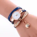 Close-up of blue wrap bracelet watch with rose gold dragonfly charms and sparkling crystals - Blue