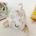 Mini-Cord-Rucksack in Cremeweiß mit schwarzen Smiley-Mustern für einen lässigen Look - Weiß
