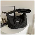 Détail d'un sac cabas noir matelassé avec surpiqûres en losange et étiquette tendance - Noir