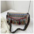 Macro detail of colorful ethnic woven shoulder bag with boho tassels and patterned strap - Navy Blue