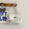 Minimalistische cremeweiße Segeltuch-Umhängetasche mit russischem Logo und Seitentaschen - Weiß