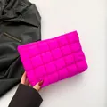 Gesteppte rosafarbene Kosmetiktasche mit goldenem Reißverschluss in der Hand - Fuchsia