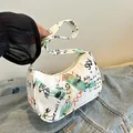 Minimalist white underarm bag with colorful graffiti prints and a secure zipper closure - Black and Orange Graffiti / Green