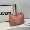 Sac cabas minimaliste en cuir rose avec logo en lettres dorées et longues bandoulières - Rose