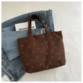 Close-up of brown corduroy tote bag with strawberry embroidery and vintage style - Coffee