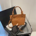 Caramel brown pebbled leather bucket bag with knot handle and adjustable crossbody strap - Brown