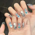 Kurze ovale handgefertigte Press-on-Nägel mit blauen Glitzerschmetterlingen und Cat-Eye-Effekt - XS