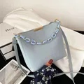 Borsa a secchiello azzurra in ecopelle con catena decorativa in acrilico dorato e tracolla - Celeste