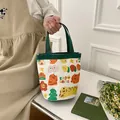 Petit sac seau en toile avec bordure verte et imprimés de tigres tenu à la main - Vert