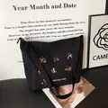 Black corduroy tote bag with colorful harvest embroidery and a wide shoulder strap - Black