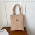 Borsa tote minimalista in velluto a coste beige con etichetta su tavolo in legno - Cachi