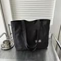 Minimalist black nylon tote bag with Fashion patch on front pocket for daily commute - Black