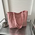 Pink canvas tote bag with front pocket and FASHION label on an industrial cart - Pink
